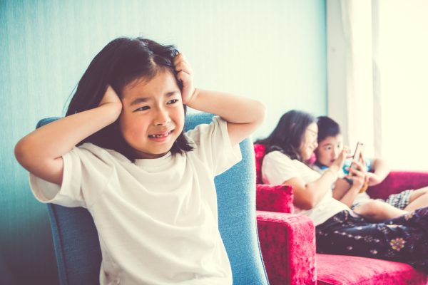 Upset,Girl,Sitting,On,Chair,Mother,Enjoying,With,Brother,On